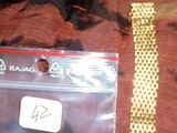 un bracelet en or avec une plaque sur laquelle est inscrit « ragg »