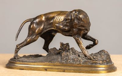 bronze statue of a dog running on a rock on a table