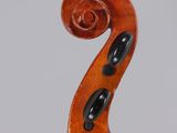 a close up of the back of a violin with a fiddle in the foreground