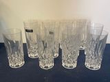 Six verres sont alignés sur une table recouverte d'une nappe noire.
