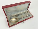 a silverware set in a red case on a white surface