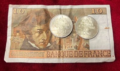 deux pièces posées sur une feuille de papier sur laquelle figure le portrait d'un homme