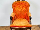an orange chair sitting on top of a wooden floor next to a white wall