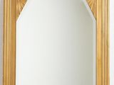 une image d'un miroir encadré d'or sur un mur blanc