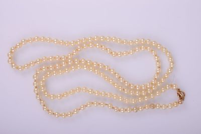 un collier de perles blanches avec un fermoir en or