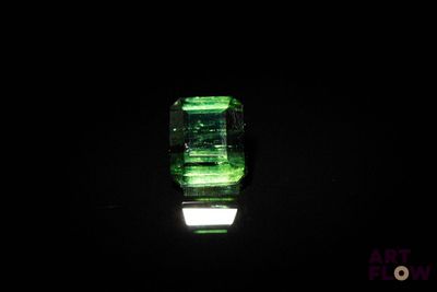 un gros plan d'une émeraude verte sur une surface noire