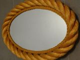 un miroir accroché au mur, entouré d'une corde