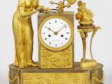 une horloge en or surmontée d'une statue