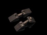trois clips métalliques sur une surface noire, avec un fond noir
