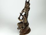 an image of a bronze statue of a man sitting on a rock