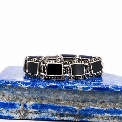 a close up of a bracelet on a rock with a white background