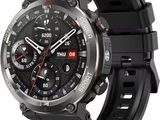 La montre connectée est dotée d'un bracelet noir et d'une trotteuse rouge.