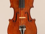 un vieux violon auquel est accroché un archet au niveau du manche