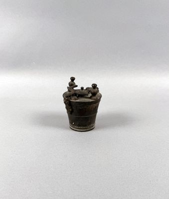 miniature figurine of a man in a bucket on a white surface