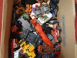une boîte en carton remplie de petits véhicules jouets de toutes sortes