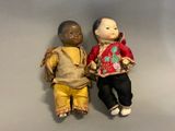 two dolls sitting next to each other on a table