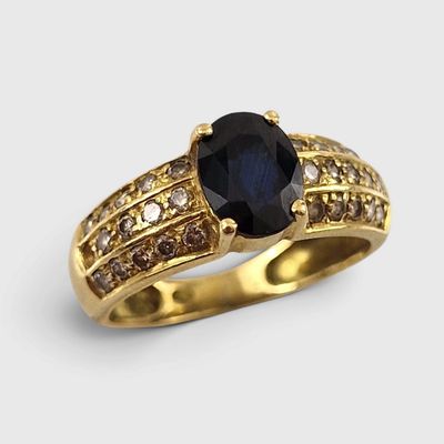 une image représentant une bague en or sertie d'un saphir entouré de diamants