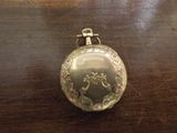une montre de poche en argent posée sur une table en bois