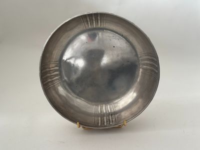 an antique silver plate on a stand on a white background