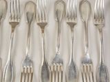 a lot of forks and spoons that are on the table