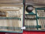 des couverts dans un coffret posé sur une table recouverte d'une nappe rouge
