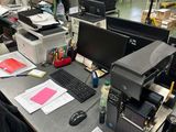 un bureau sur lequel se trouvent un ordinateur, une imprimante et d'autres objets