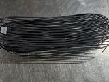 un gros plan sur un enchevêtrement de fils noirs posés sur une surface métallique
