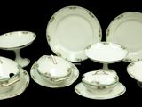 a lot of white plates and bowls on a table