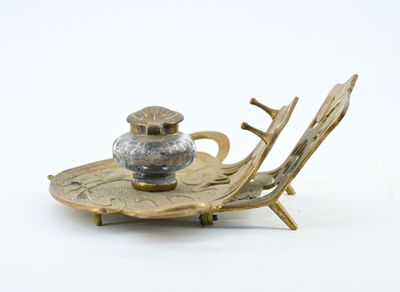 a silver and gold plate with a bird on it