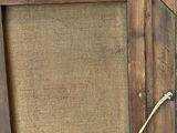 an old picture frame with a rope hanging from it ' s side