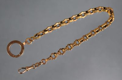 gros plan d'une chaîne en or sur laquelle est fixée une bague