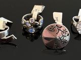 four different types of rings on a black surface with a price tag