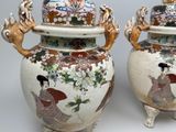 two vases with asian designs on them sitting on a table