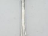 a silver spoon with a spoon handle on a white surface