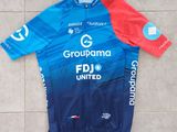 un gros plan sur un maillot bleu et rouge posé sur un sol carrelé