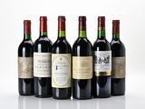 six bottles of wine are lined up on a white surface
