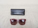 sunglasses and a case on a table with a white background