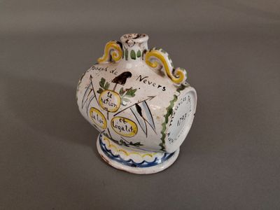 un petit vase avec un oiseau sur une table