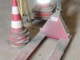 a pair of skis sitting on the ground next to a traffic cone