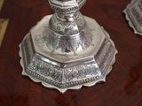 a silver candle holder on a wooden table
