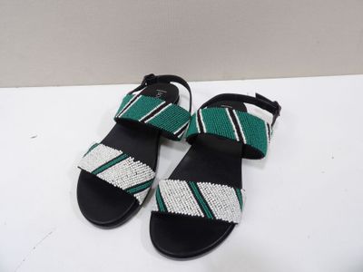 a pair of black sandals with green and white stripes