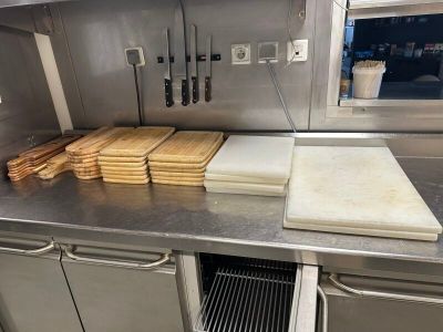 de nombreuses planches à découper et de nombreux couteaux sur le plan de travail de la cuisine