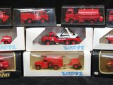 six camions de pompiers rouges dans des boîtes, sur fond noir