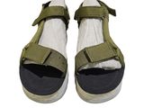 une paire de sandales vertes et blanches à lanières sur fond blanc