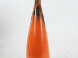 an orange vase with a black top on a white background