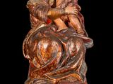 statue of a woman holding a child on a horse on a wooden base