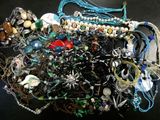 a pile of assorted jewelry on a black surface