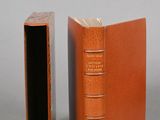 an orange book sitting next to a closed book on top of a table
