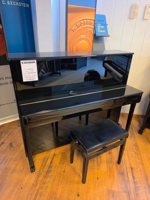 black piano and stool in a room with a blue wall