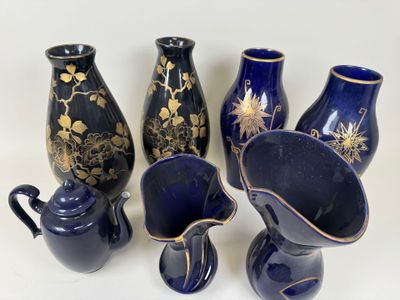 five blue vases with gold designs on them on a white surface